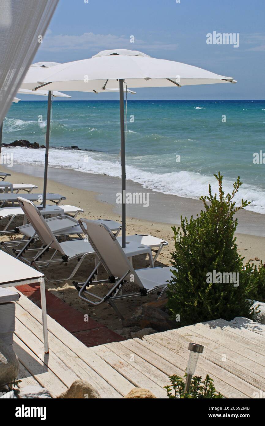 Skala Fourkas, Halkidiki/Greece – August 6, 2015: Skala Fourka beach with sunbeds near the palm trees, Chalkidiki, Greece. Stock Photo