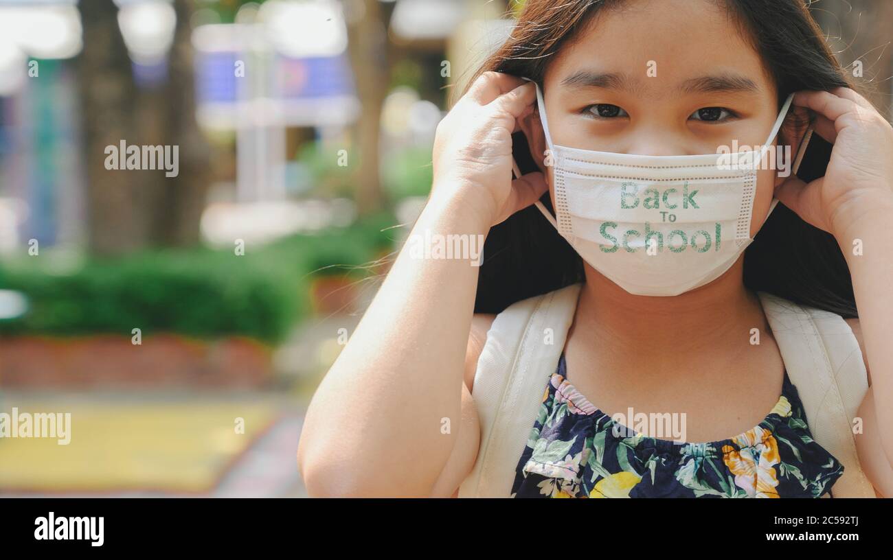 Back to school. asian child girl wearing face mask with backpack going