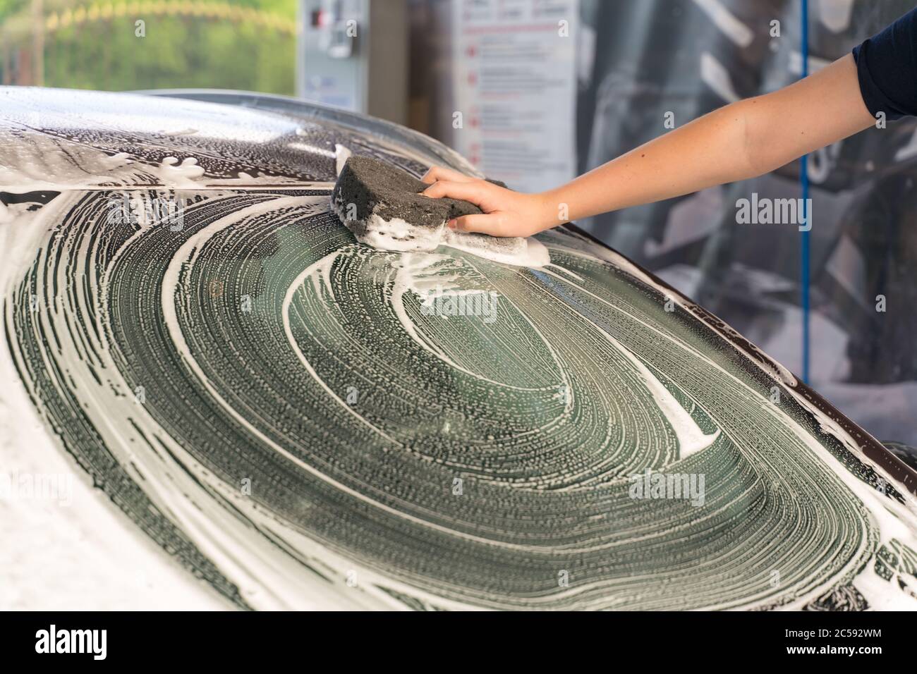 young man washes his car with a sponge Stock Photo