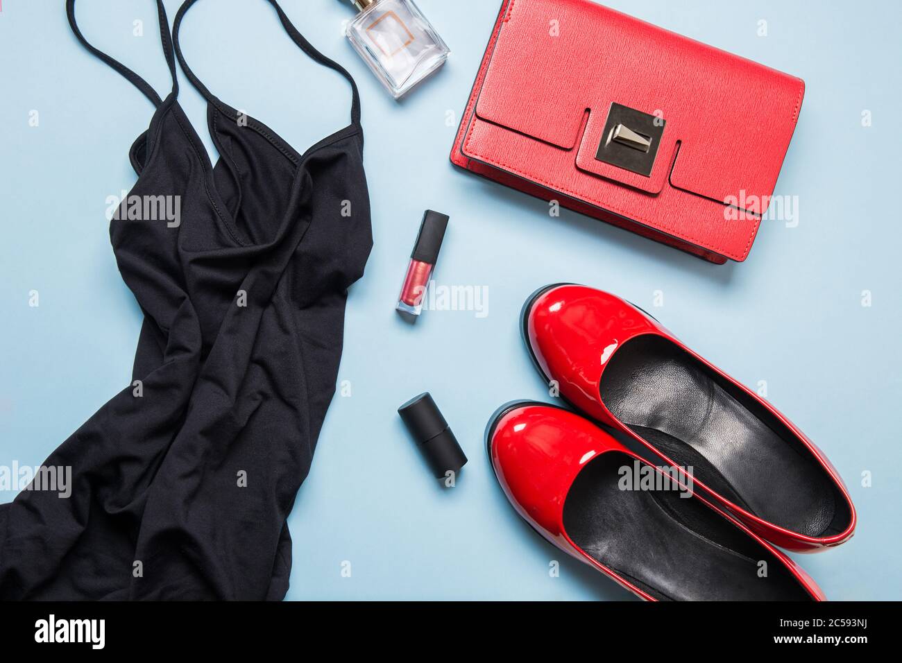 Elegant little women's black dress and red accessories for party. Flat lay. Stock Photo