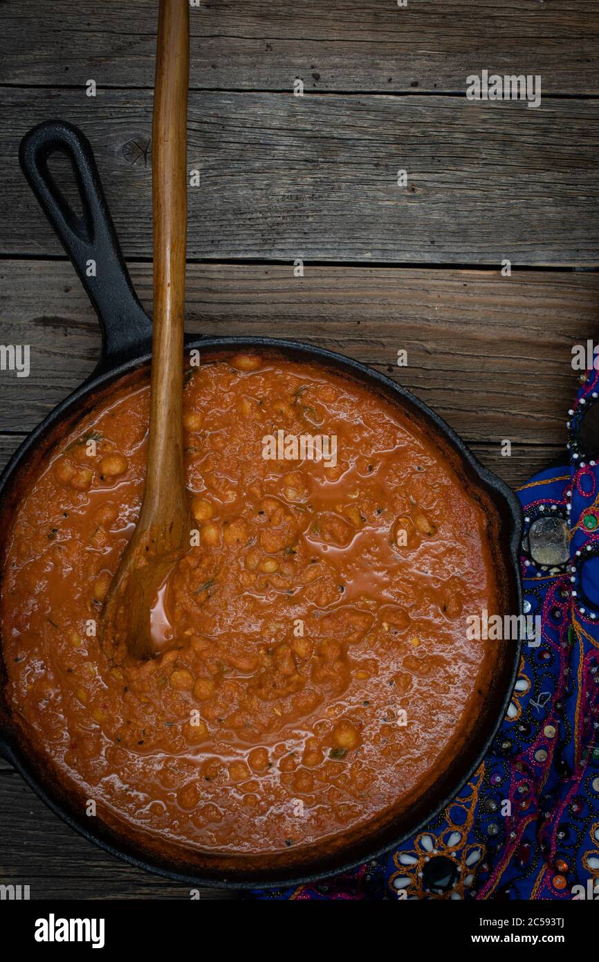 Indian chickpea garbanzo chole masala curry in cast iron pan, copy