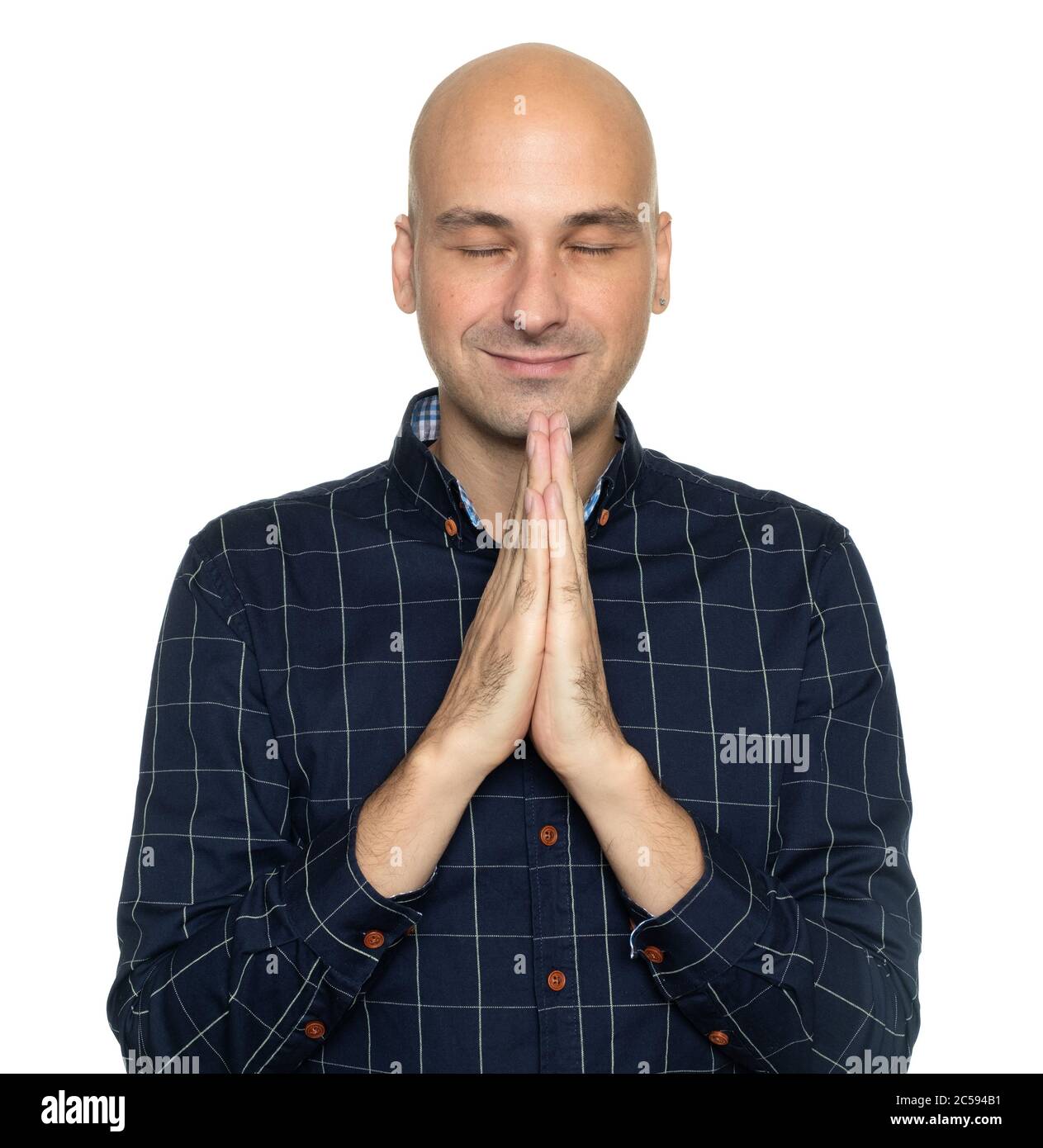 Happy middle aged bald man praying. Isolated on white Stock Photo