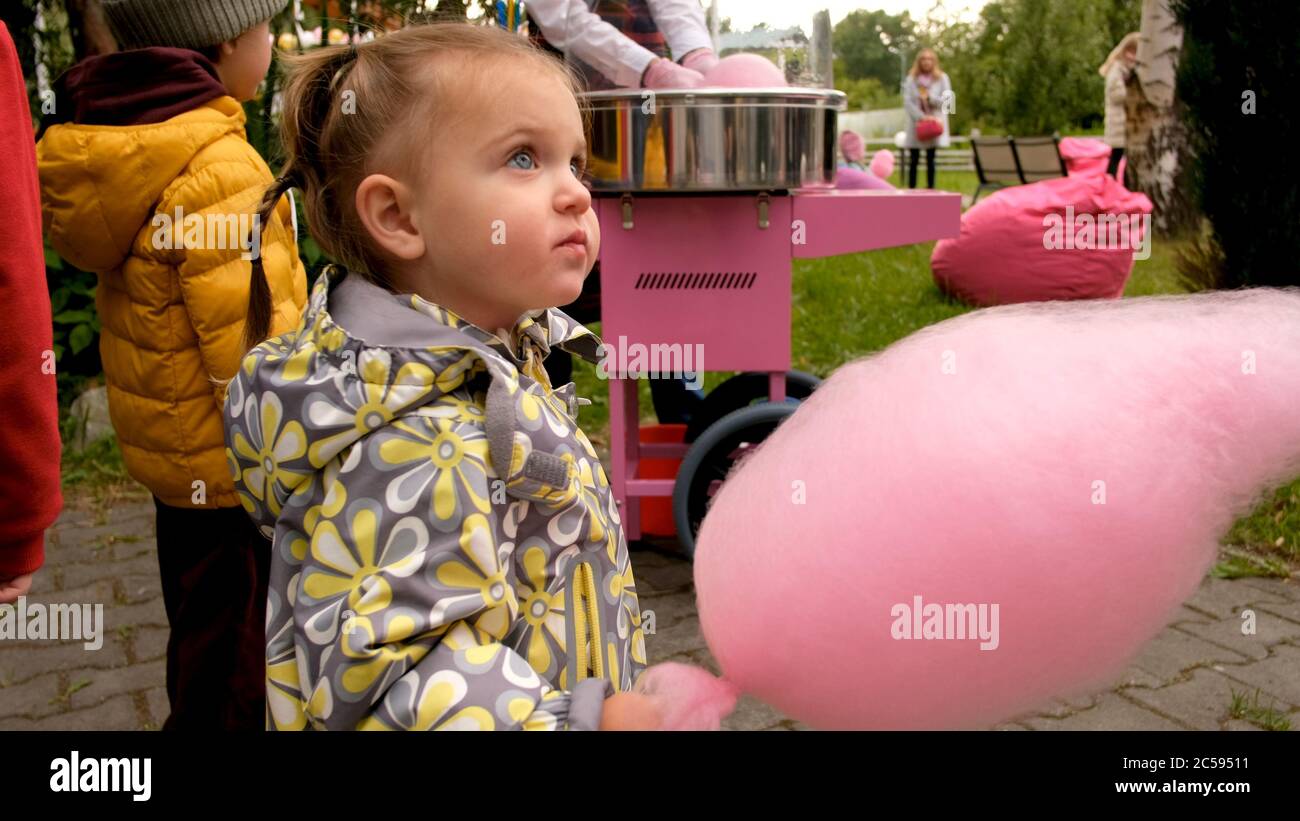 Girl eating candy floss in park Stock Photo