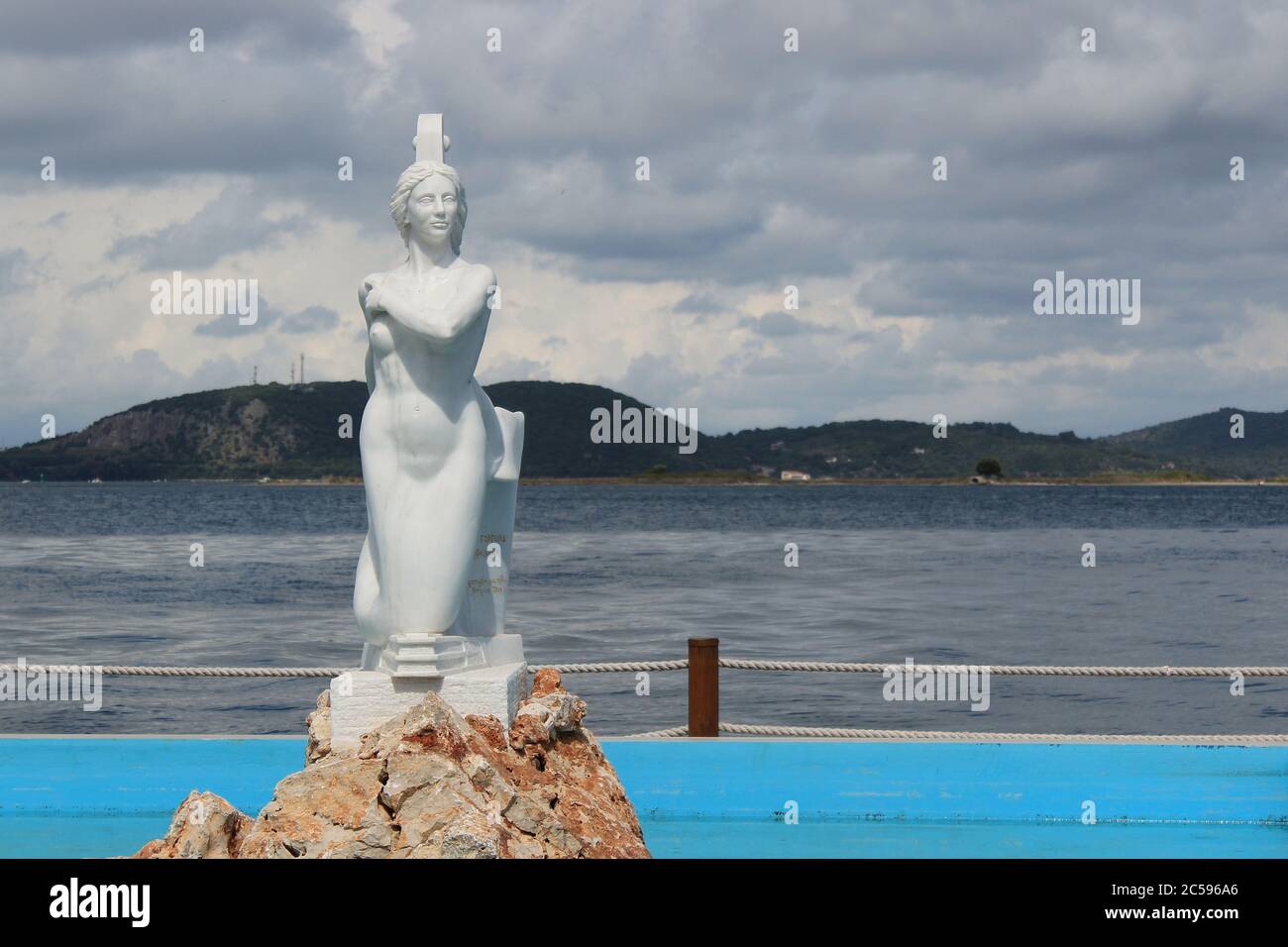 Preveza, Epirus / Greece - 05/21/2020: Mermaid sculpture in a fountain in port of Preveza town in Greece. Soft focus at the Ambracian gulf at the back Stock Photo