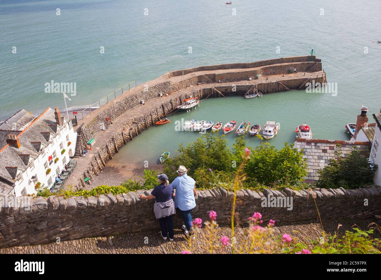 Middle aged couple enjoying the view over Clovelly harbour, North Devon, England, Summer Stock Photo