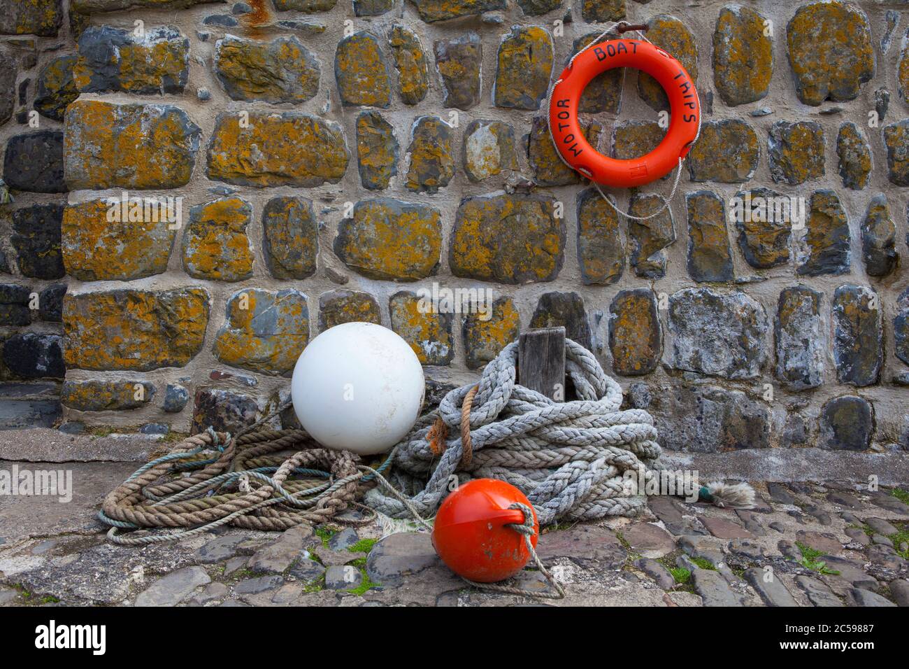 Rope, life ring and buoys on the stone harbour wall at Clovelly, North Devon. Stock Photo