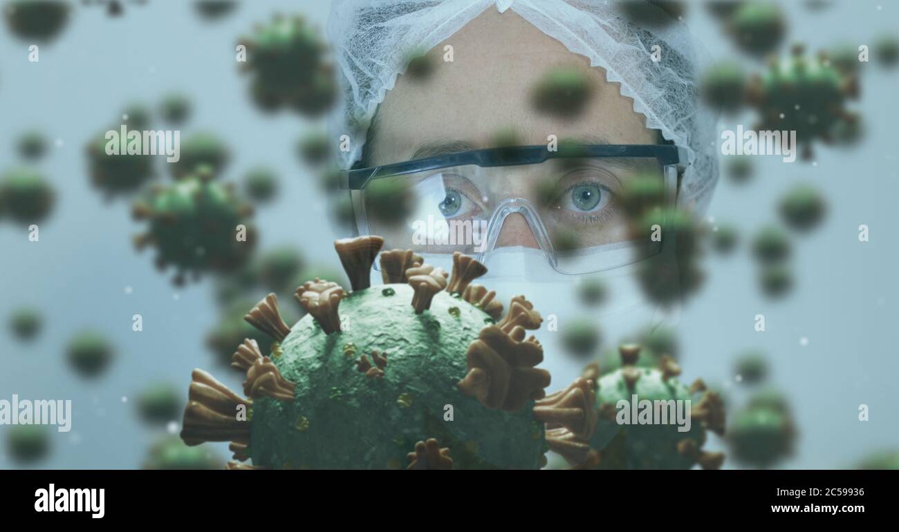 Covid-19 cells against scientist wearing face mask Stock Photo