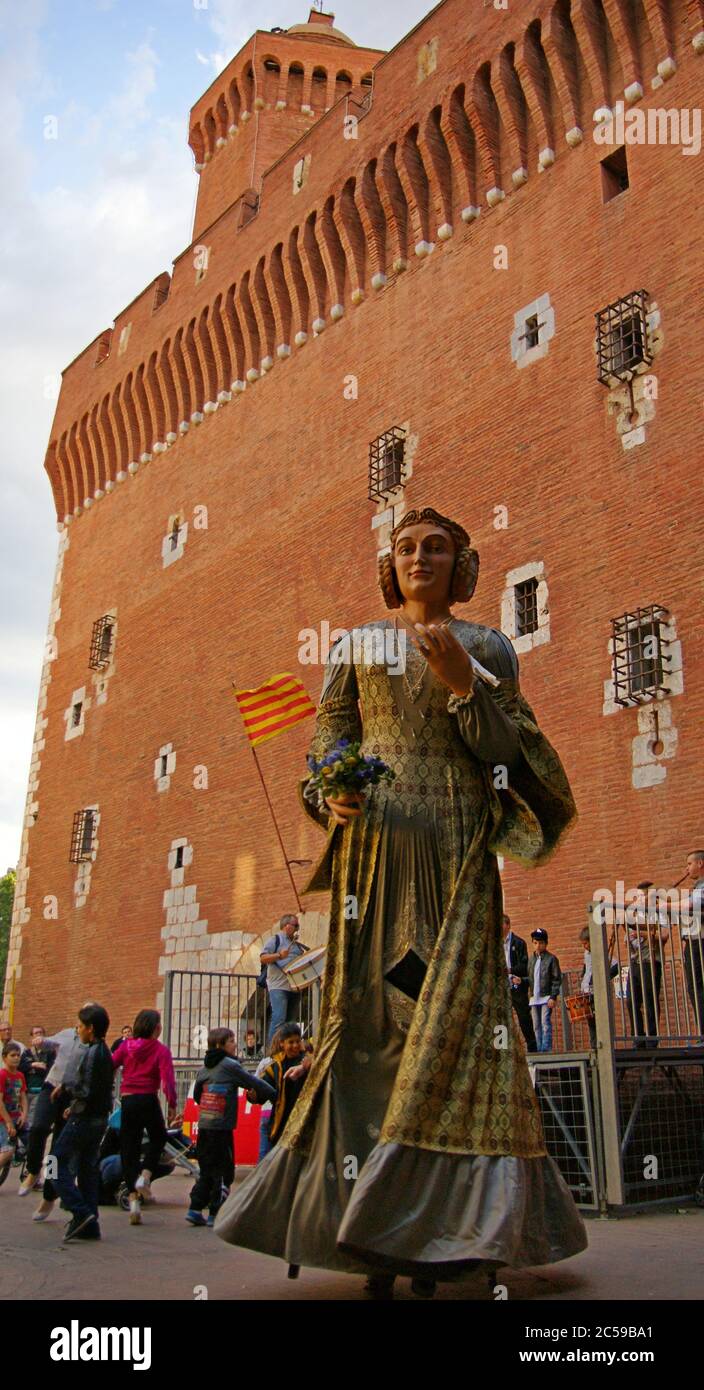 Giant King and Queen dance in front of the Castillet in Perpignan to the music of a catalan cobla troupe. Stock Photo