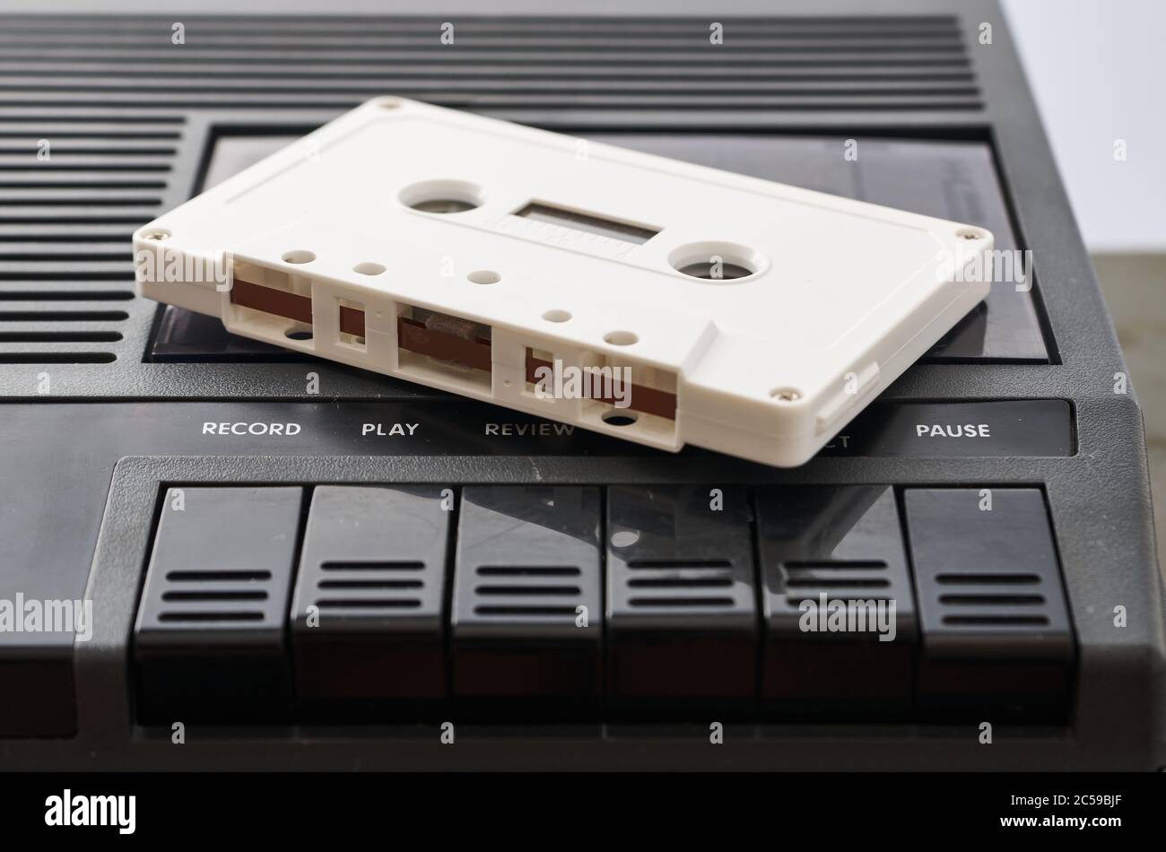 White audio cassette without markings on a black tape player. Close-up shot Stock Photo