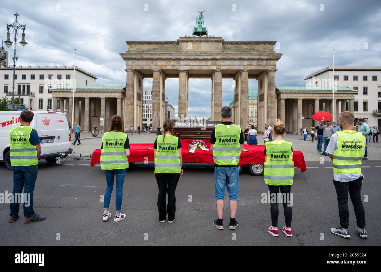 Berlin, Germany. 01st July, 2020. Demonstrators stand in front of the Brandenburg Gate wearing high-visibility vests with the inscription 'Veranstaltungsbranche - #wsdsn- Wir schaffen das so nicht'. Under the motto 'We can't do it this way', entrepreneurs of the event industry have organized a car demonstration and are protesting against the ban on large events until at least the end of October. Credit: Christophe Gateau/dpa/Alamy Live News Stock Photo