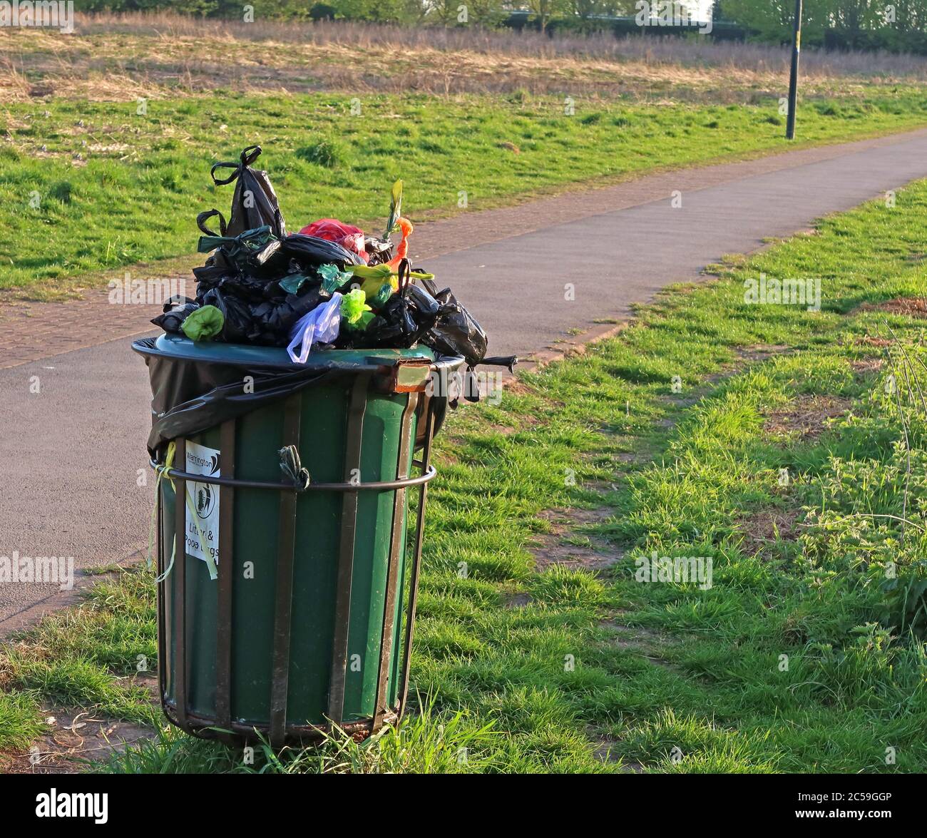 Overflowing dog waste bin, Grappenhall Heys, Warrington,Cheshire,England,UK,WA4 3DS Stock Photo