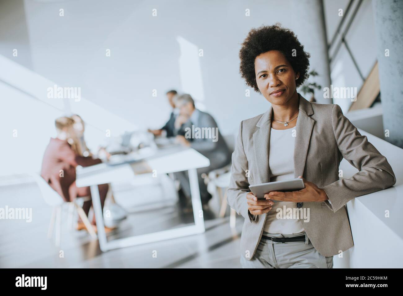 Young African American businesswoman standing using digital tablet in the modern office Stock Photo