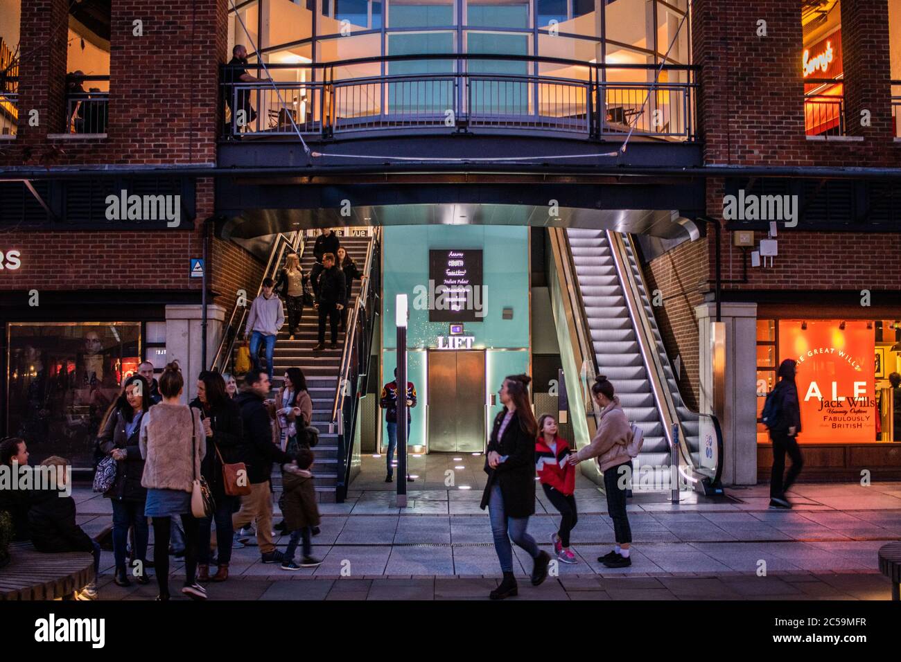 Groups of people at an open air shopping centre or shopping mall doing