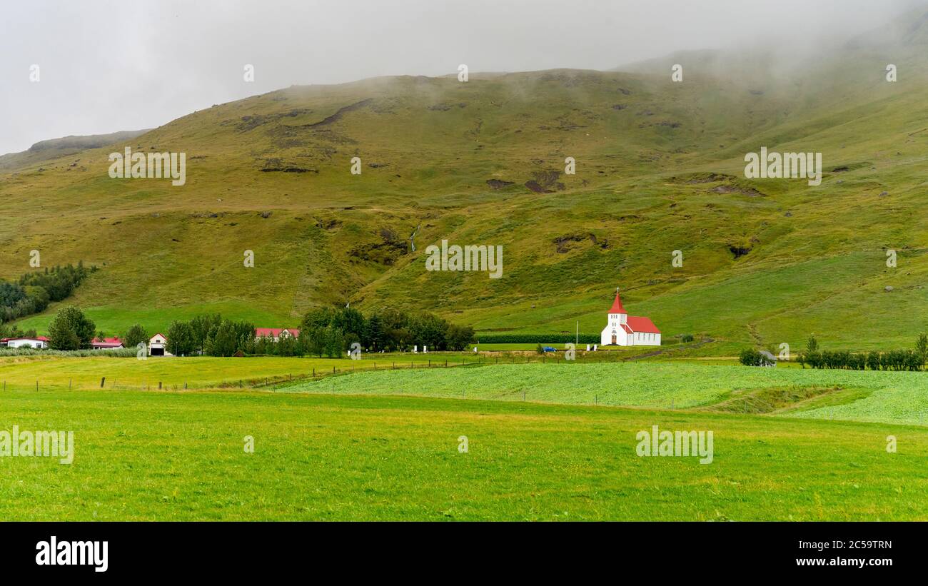 Classic White Church In The Middle Of Green Mossy Hills In Iceland 