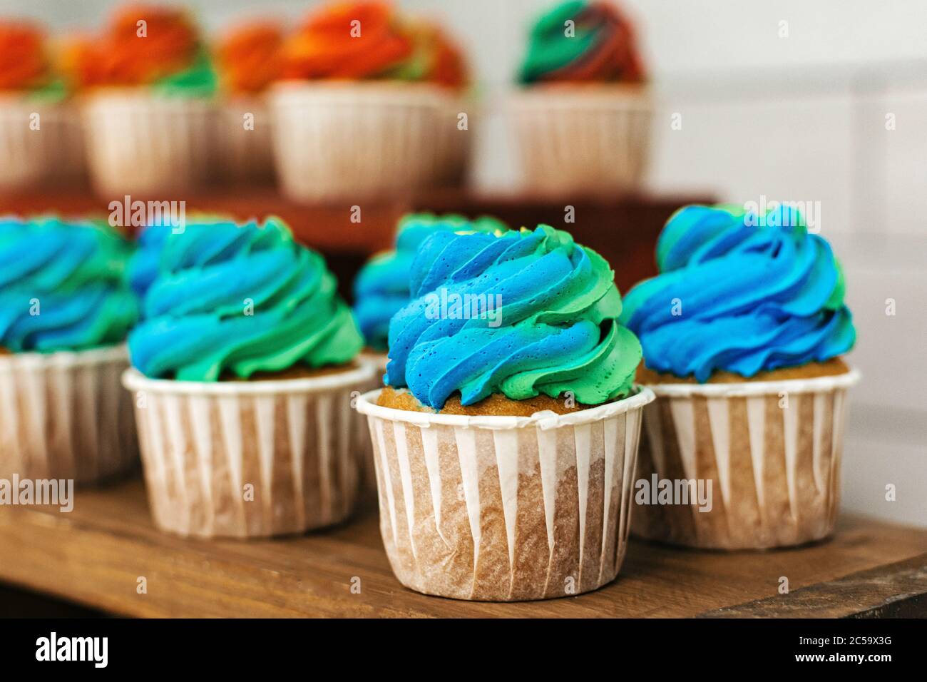 Colored cakes in baskets on a wooden table Stock Photo