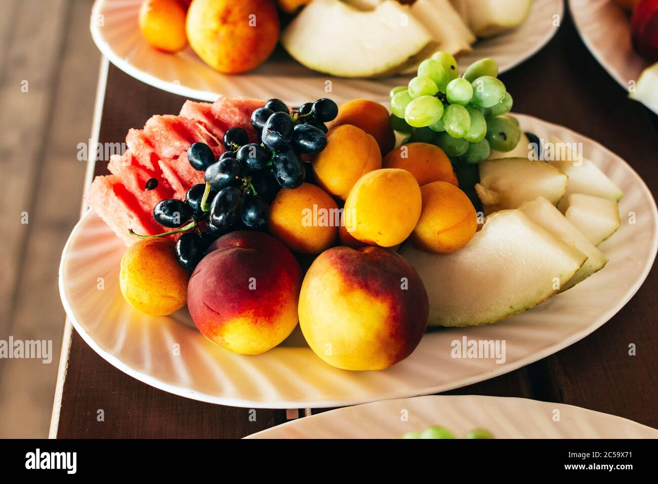 Plates with fruits on a wooden table closeup Stock Photo