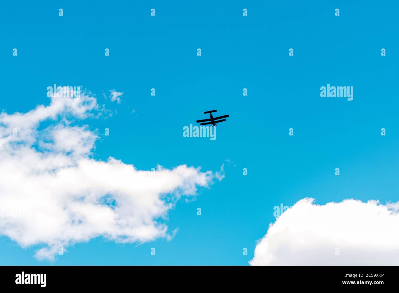Flying airplane in the blue sky with clouds Stock Photo - Alamy