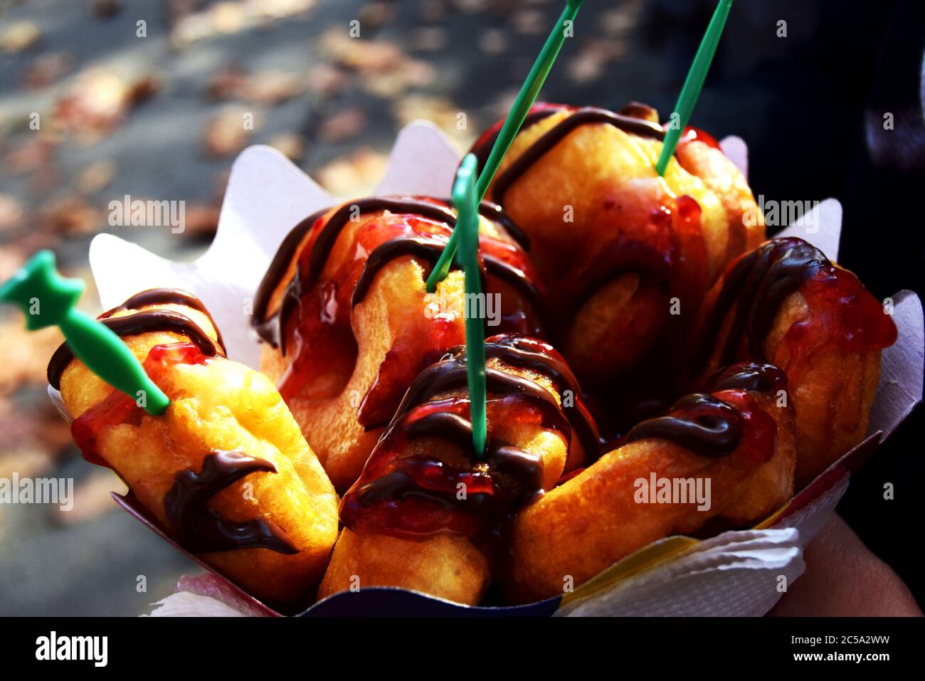 Carton of mini donuts glazed with raspberry sweetness and chocolate ...