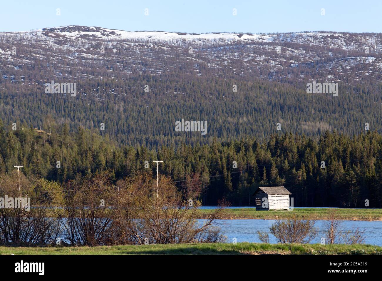 Water from a flooded river cover a delta land. Wooden barns on the