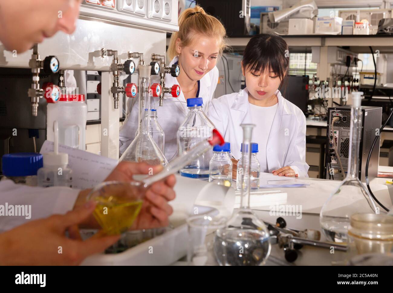 Two female students of Faculty of Chemistry performing experiments in