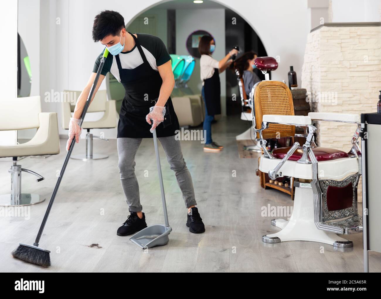 Barber cleaning floor hairdresser salon hires stock photography and