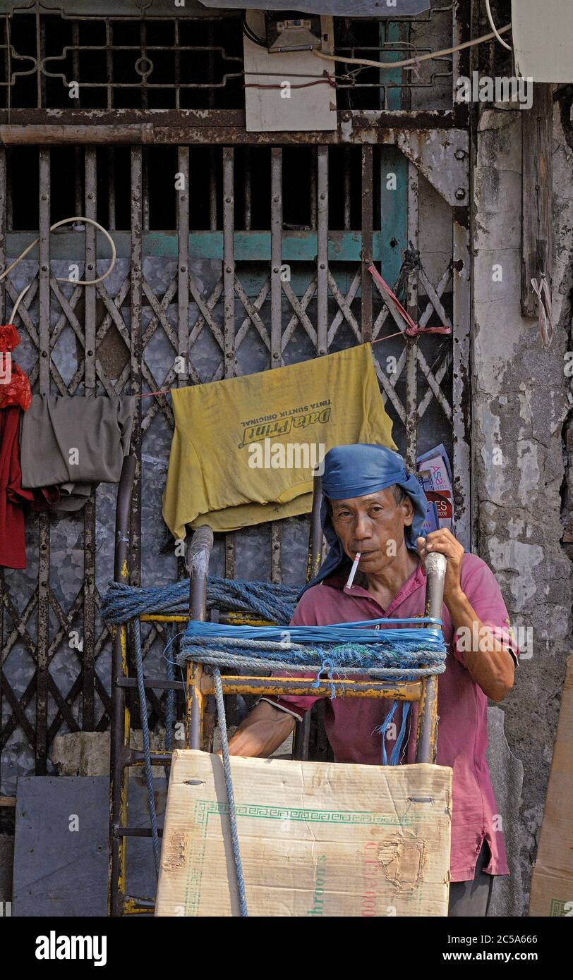 jakarta, dki jakarta/indonesia - may 26, 2010: a porter with his cart having a break in front of a shop house in glodok jakarta chinatown   d100126 (7 Stock Photo