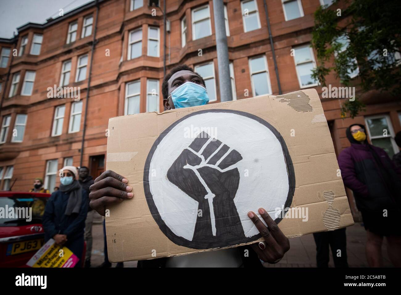 Activists from Stand Up to Racism hold a demonstration outside the Home Office's Glasgow Immigration Enforcement Reporting Centre to demand change and the end of hotel detention of refugees, following the incident on Friday June 26 at Glasgow's Park Inn Hotel, in which three people were stabbed to death and six people including a police officer were seriously injured. Stock Photo