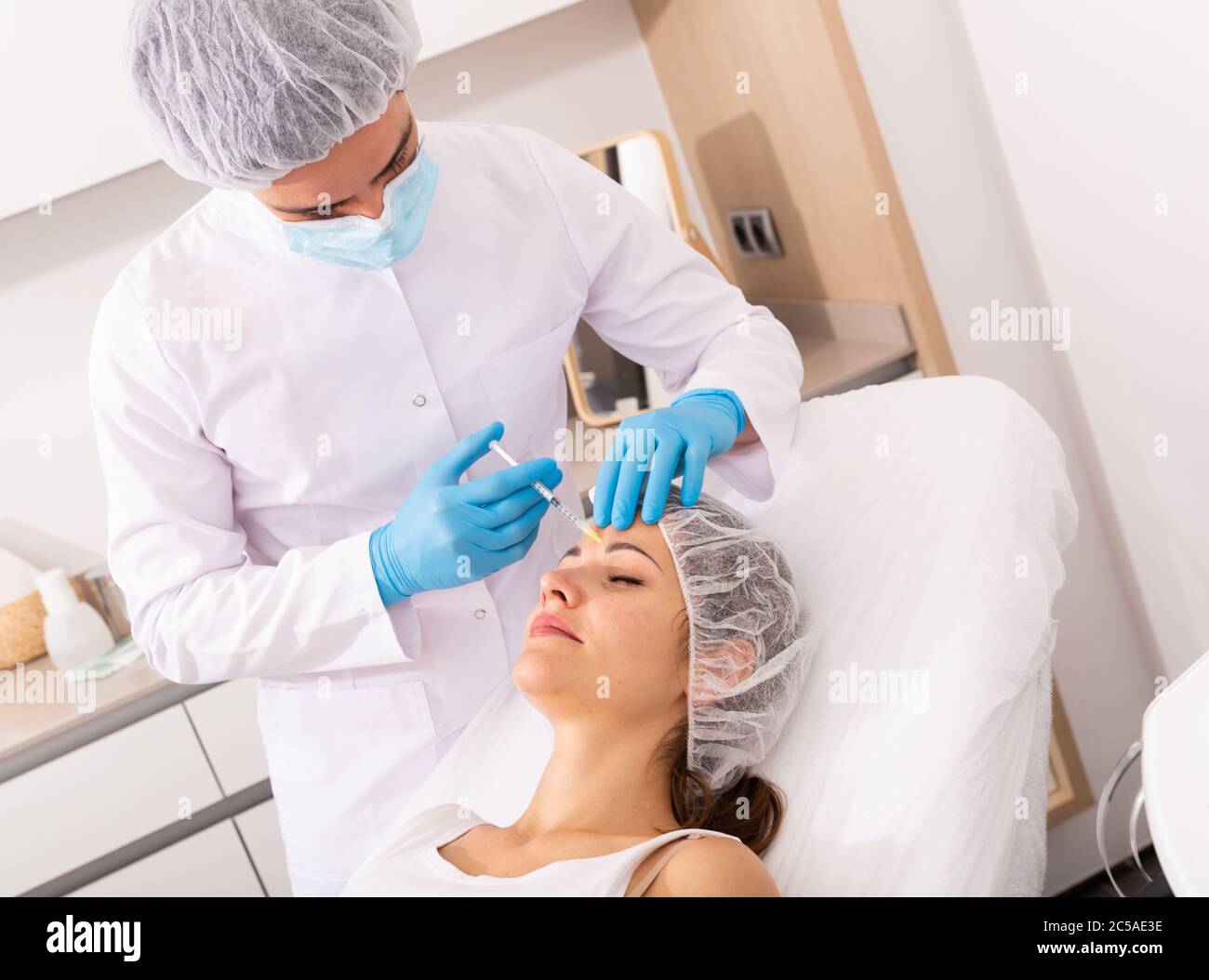 Teaching Client Injection Qualified focused cosmetologist giving beauty injections for face skin ...