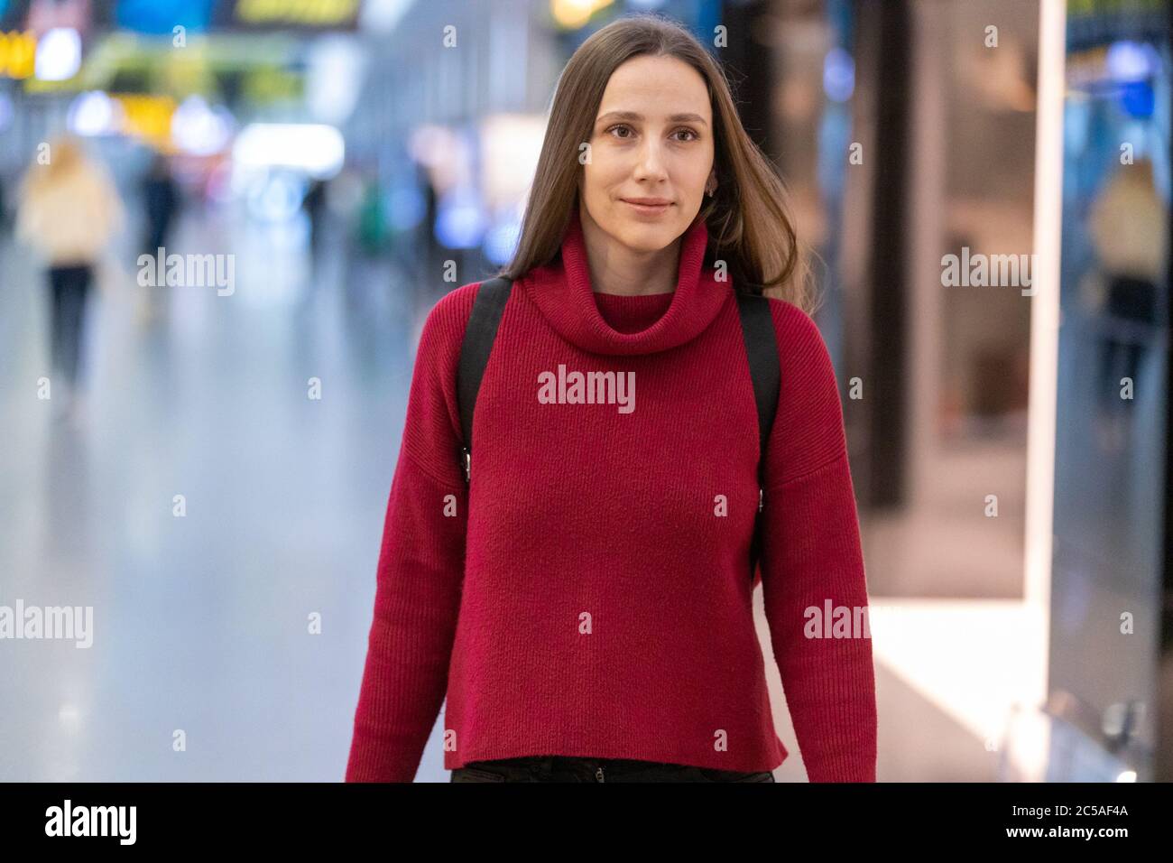 Young smiling woman in red sweater at the shopping mall Stock Photo - Alamy