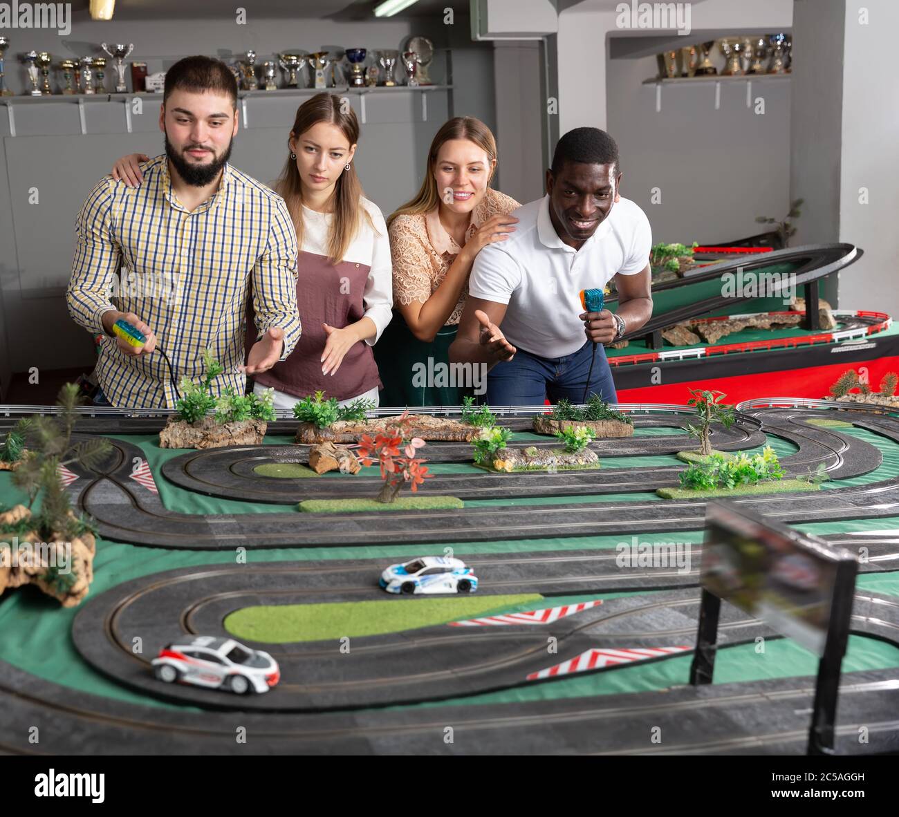 Two teams frompairs play slot car racing game Stock Photo Alamy