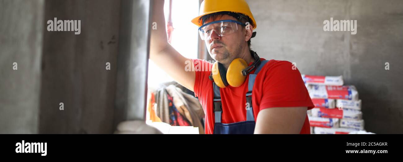 Builder measures level wall at construction site Stock Photo