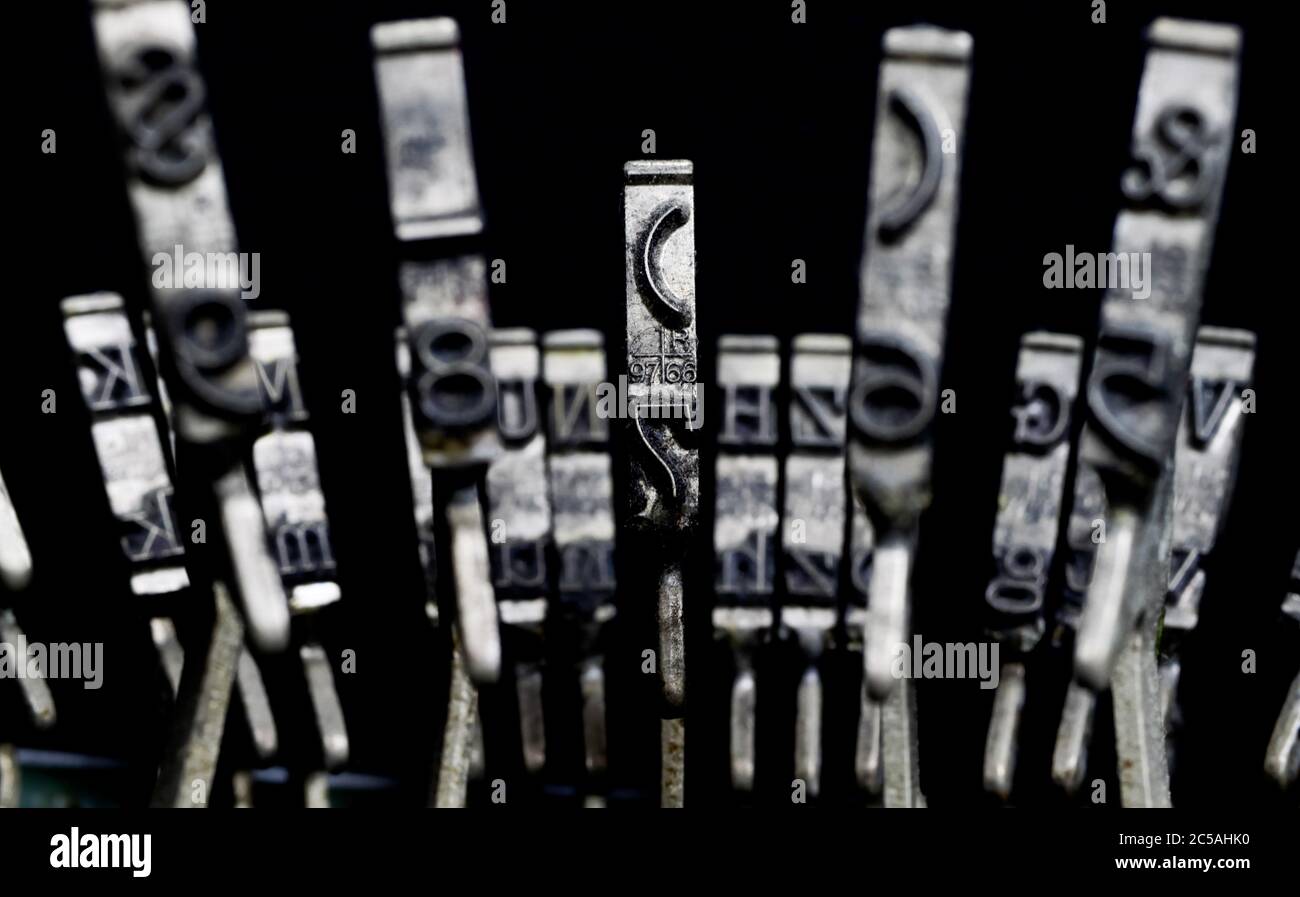 Macro closeup of isolated type bars of old typewriter with letters and symbols, black background Stock Photo