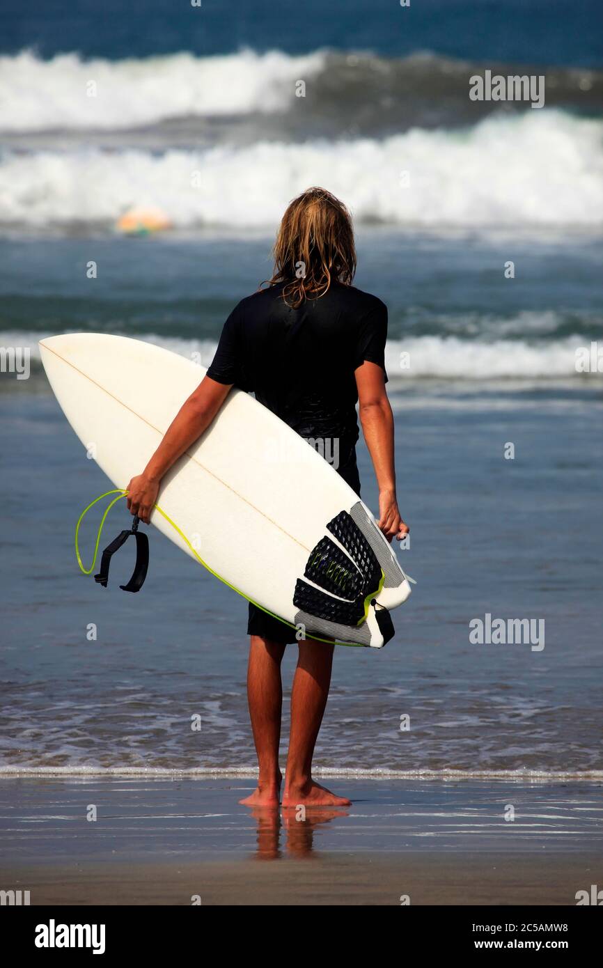 Lonely the man-surfer on a coastline. Bali Stock Photo