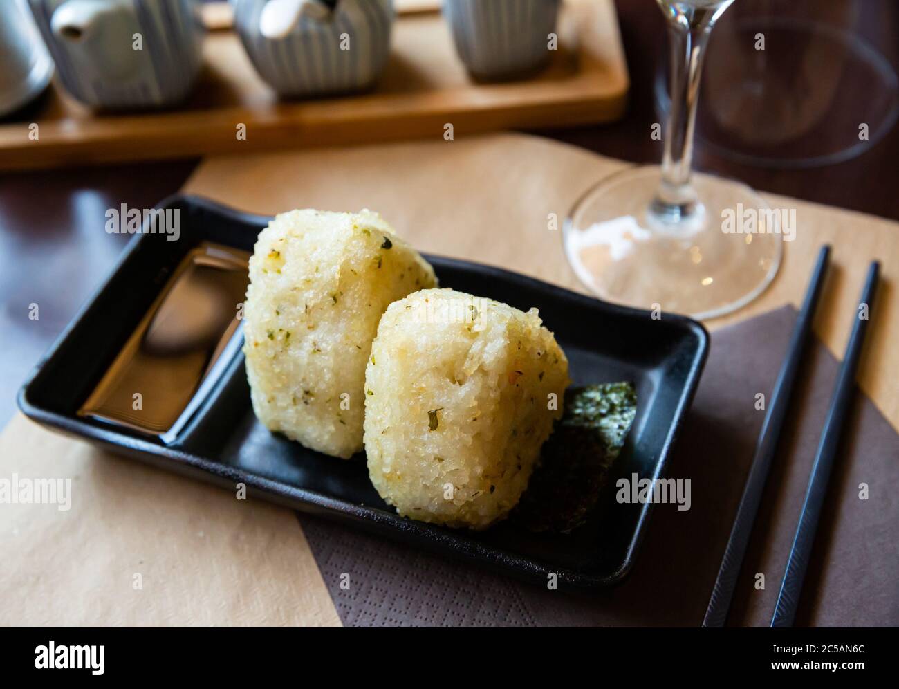Nigiri Triangular Rice Fresh Japanese triangular onigiri with rice at black plate, nobody ...