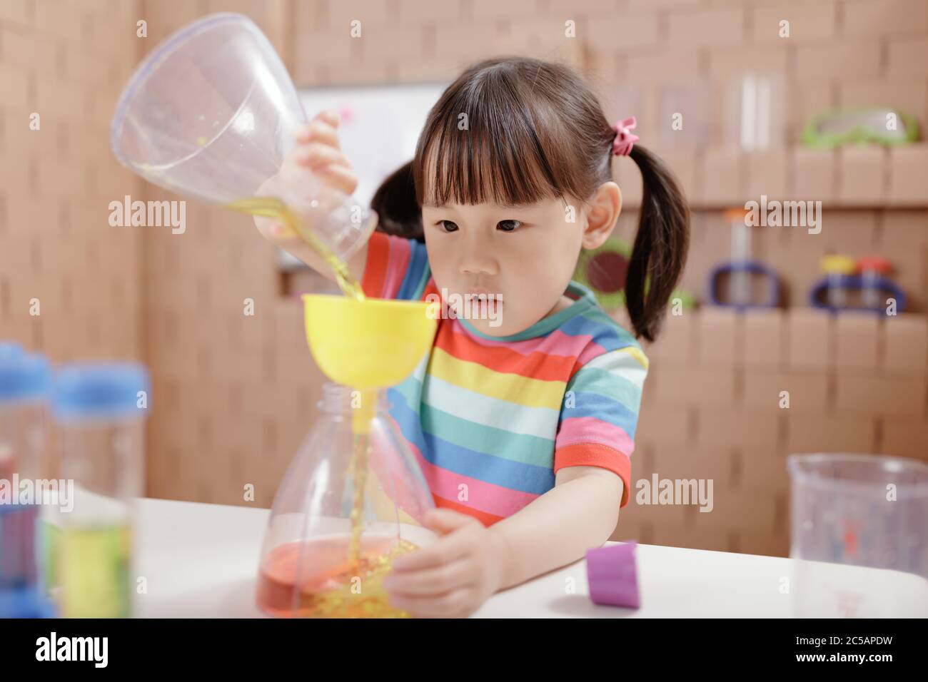 Experiment Play toddler girl play science experiments for homeschooling Stock Photo - Alamy