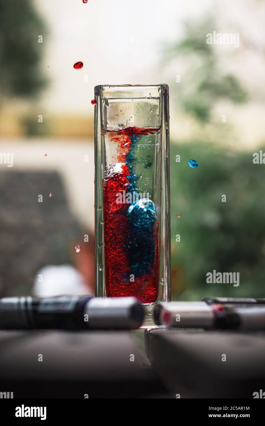 Vertical shot of red and blue ink mixing beautifully with water in a glass  Stock Photo - Alamy