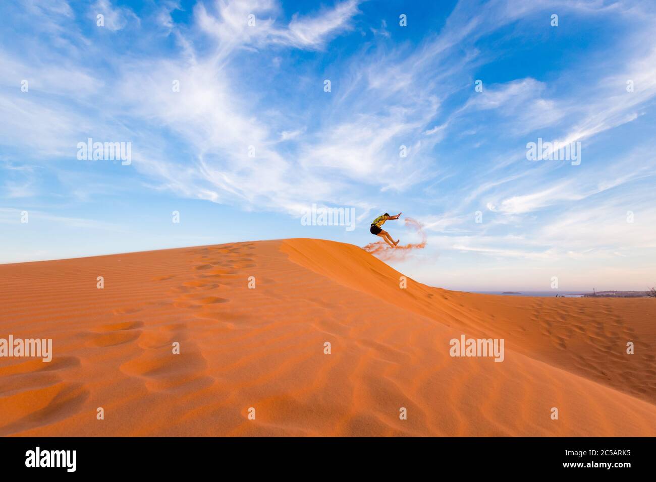 Young handsome man having fun on Red sand dunes in Mui Ne, Phan Tiet ...