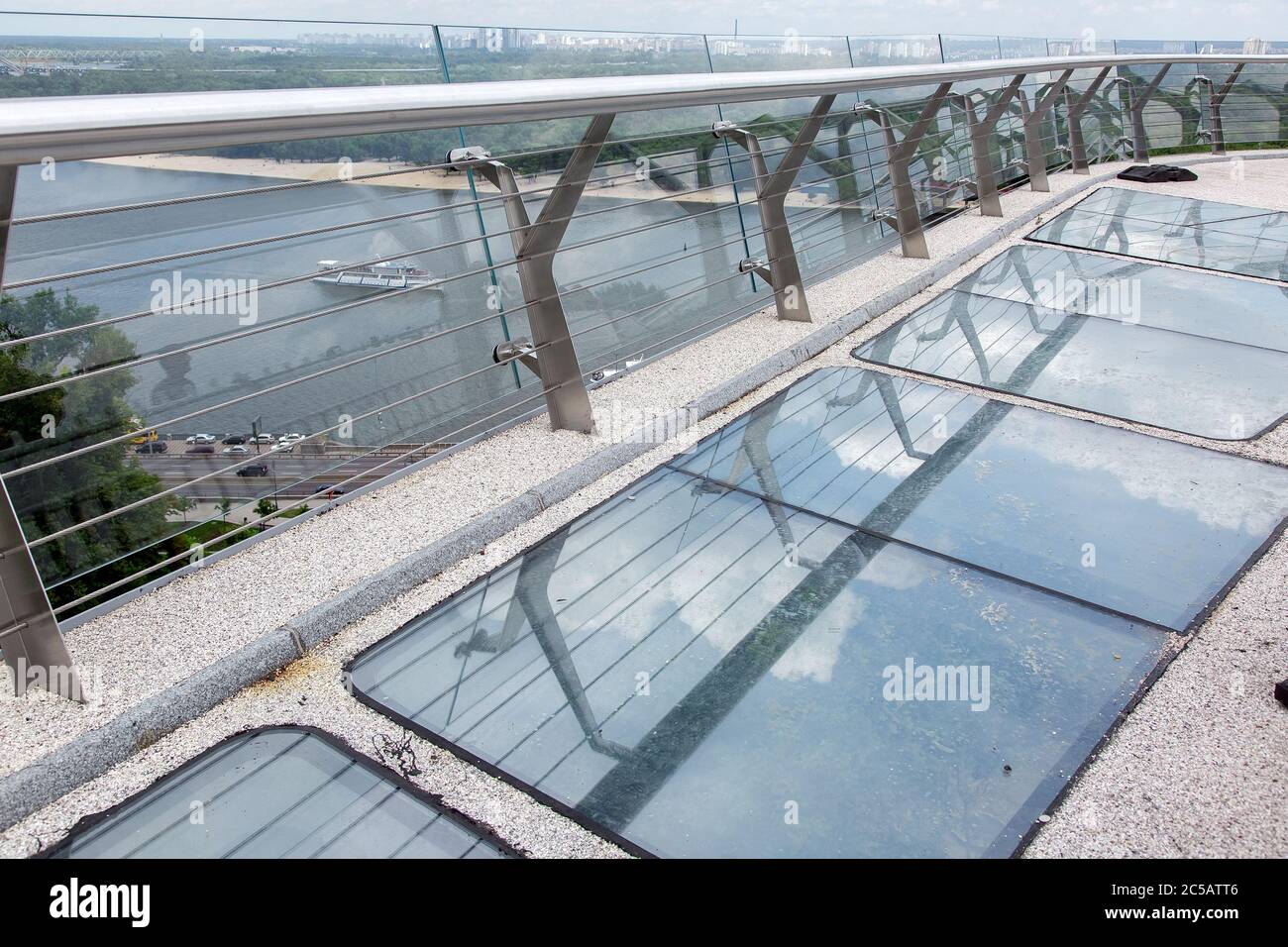 pedestrian bridge with gravel and glass inserts and iron railings ...