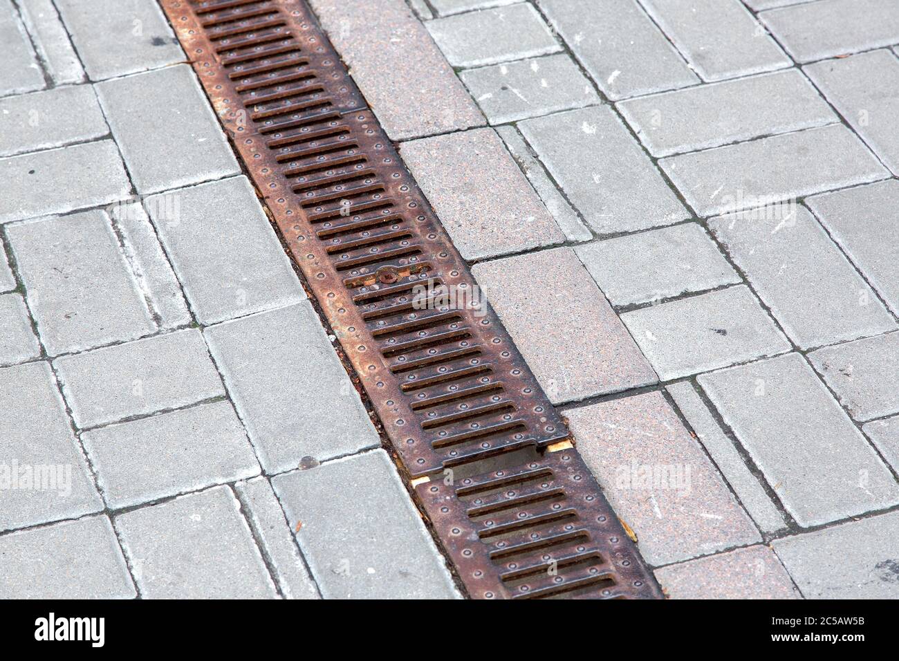 A rust lattice of a drainage paving system on a walkway made of square ...