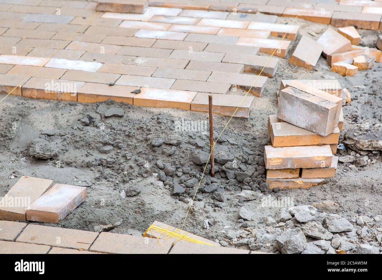 Paving Thread paving of a new sidewalk from rectangular stone tiles according to the ...