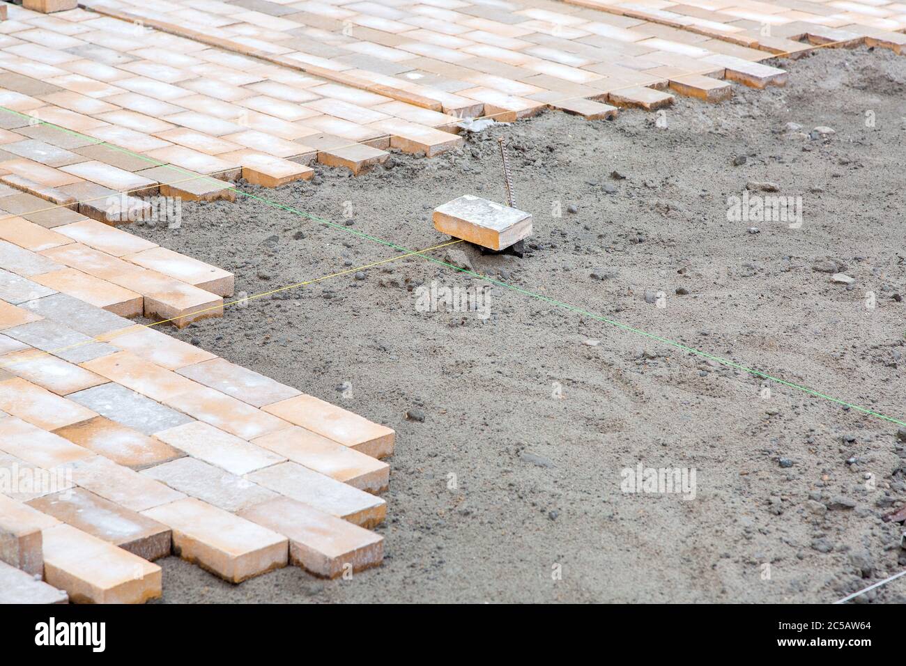 Paving Thread paving of a new sidewalk from rectangular stone tiles according to the ...