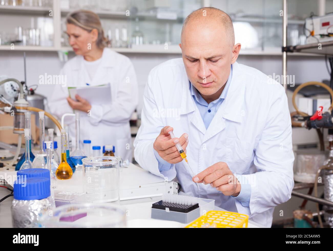 Experienced chemist working in research laboratory, analyzing liquid samples Stock Photo