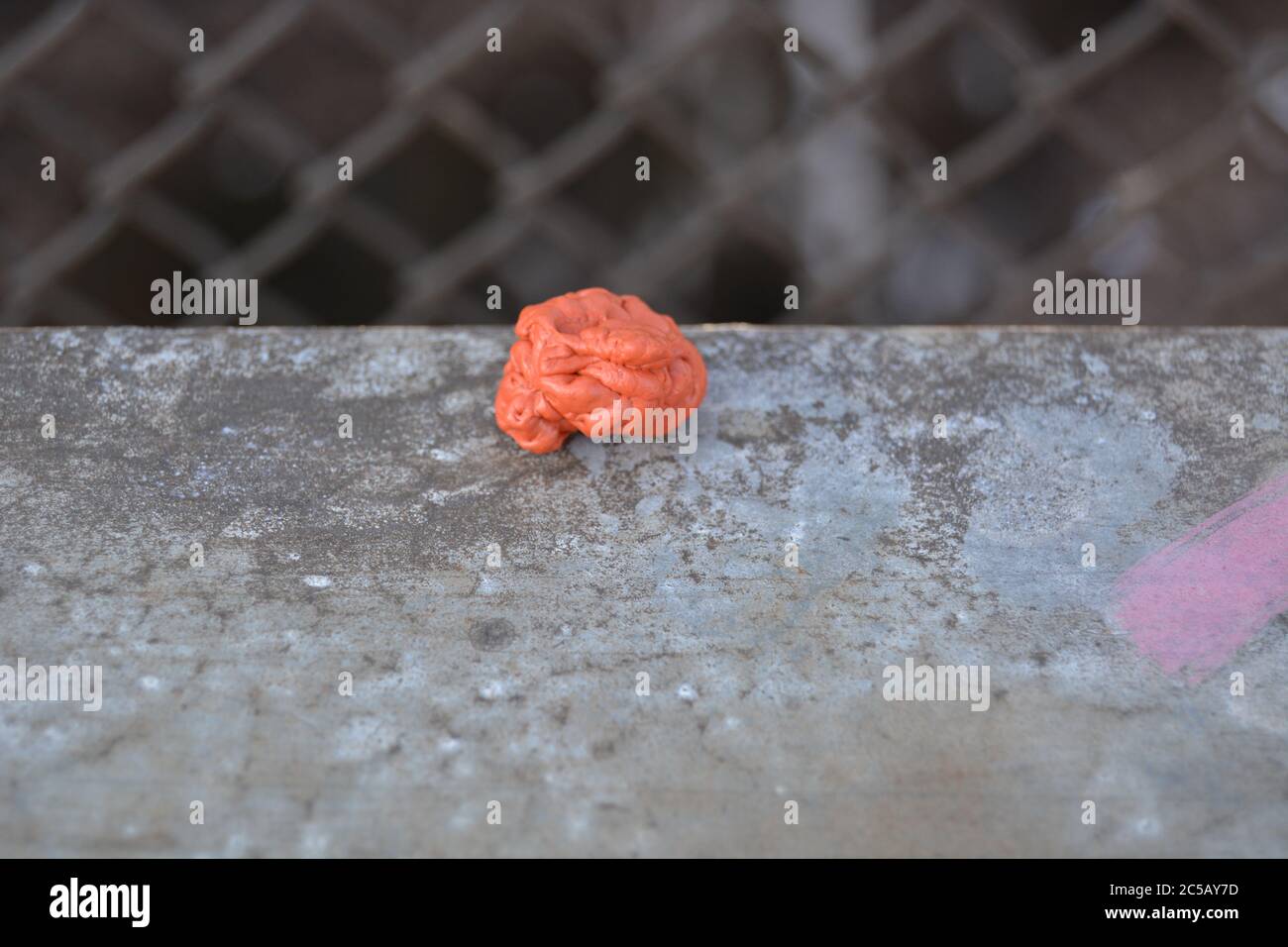 Orange chewing gum on the ground of the street. Environment.Discarded Chewing gum close up Stock Photo