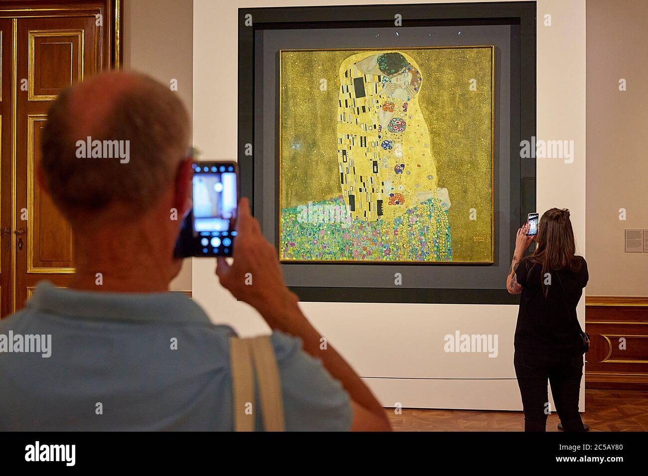 Vienna, Austria. 1st July, 2020. People take photos of The Kiss (Lovers) by Gustav Klimt at the Upper Belvedere in Vienna, Austria, on July 1, 2020. The Upper Belvedere reopened to visitors on Wednesday after a temporary closure due to the COVID-19 pandemic. Credit: Georges Schneider/Xinhua/Alamy Live News Stock Photo