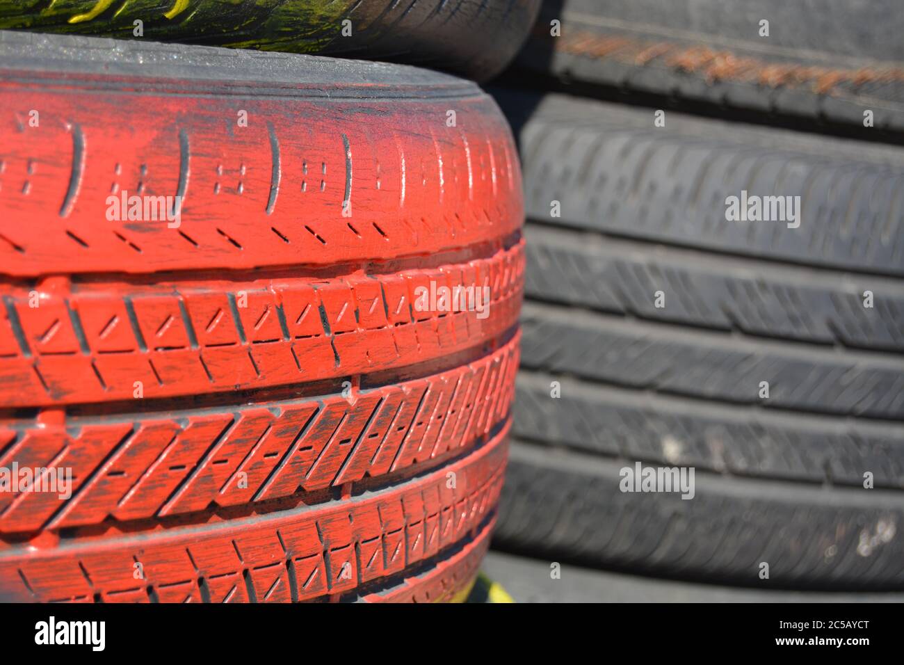 Tires. Red car tires vertically stacked / piled up. Good background for