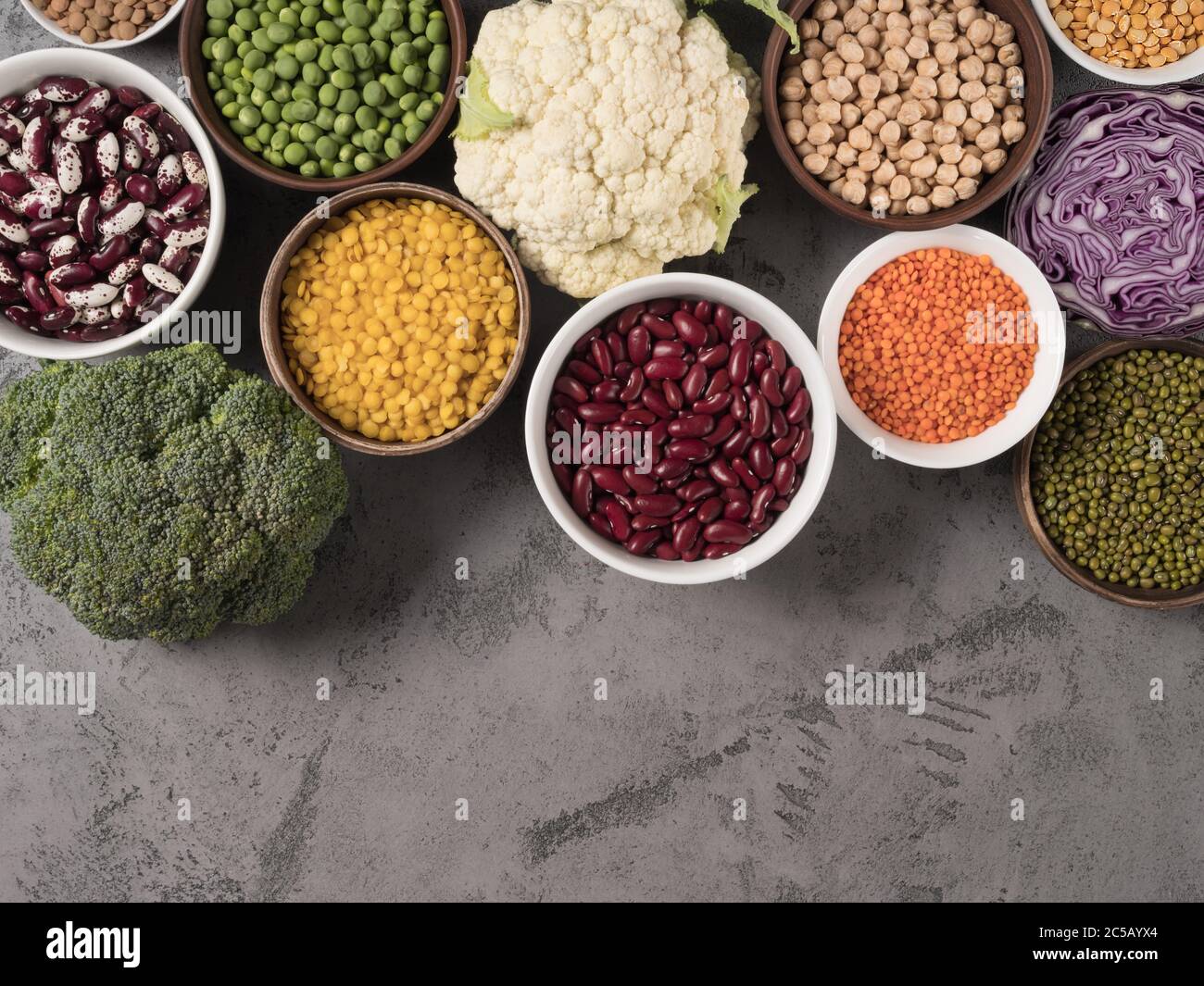 Assorted fresh cabbage and different legumes on gray background. Stock Photo