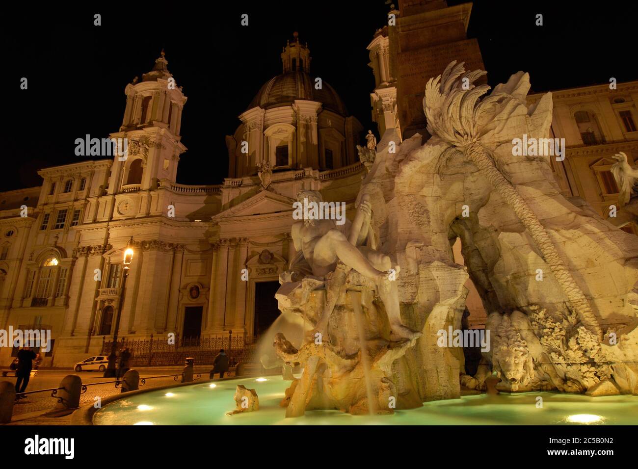 Night view of the famous Piazza Navona square in Rome with the wonderful baroque Fountain of Four Rivers and St Agnes in Agone Church, created by arti Stock Photo