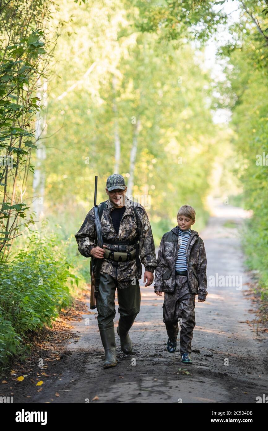 Father and son hunting together. Walking the road after the bird hunt