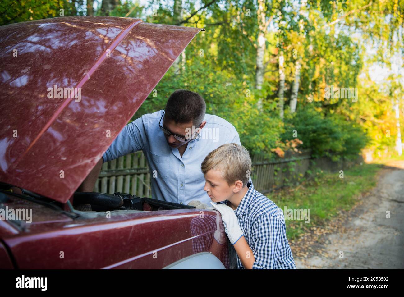 A father and son working together restoring an engine of their truck