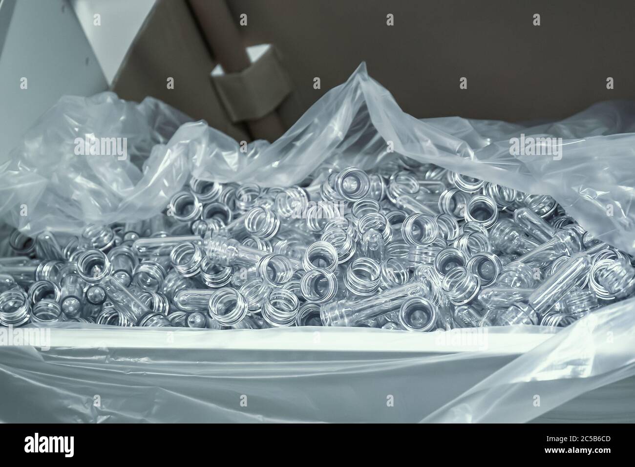 PET preforms for blowing plastic bottles in factory. Stock Photo